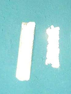 Examination of the back side of the delaminated paint shows that white texture is attached to the rear of the paint as shown in photo #1.