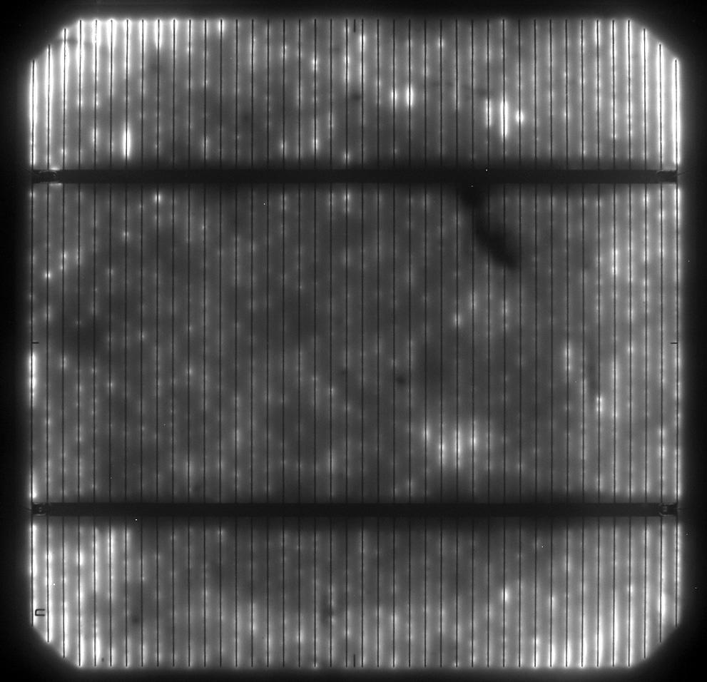 Image of a mono-crystalline solar cell, which is operated under forward bias condition. The electroluminescence (EL) of the cell below the bus bar and the grid electrodes is clearly visible.