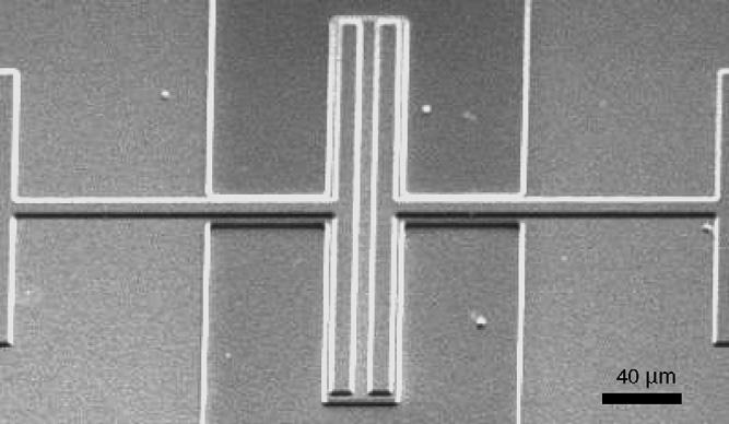 The silicon nitride is patterned to open contact holes to bias the silicon resonator (Fig. 4(a)).