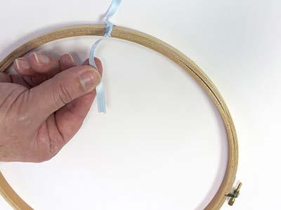 To begin assembling the mobile, lay the hand embroidery hoop flat.