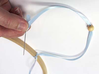 the hoop. Then, add a couple of drops of fabric glue to the knot to secure it in place.