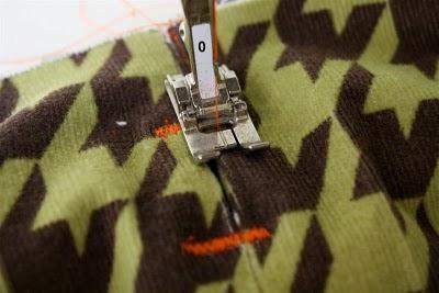 Using the presser foot to guide you in a straight line (line up the left edge of your foot with the seam, or