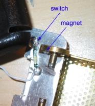 Position the switch close enough to one of the grill wheels so that the board comes on when the magnet is on the inside of one of the wheels. Hot glue the switch in place.