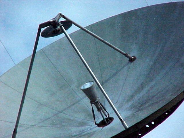 With a conventional prime-focus dish, the feed is at the focal point, out in front of the parabolic reflector, so either a lossy feedline is necessary or part of the equipment is placed near the feed.