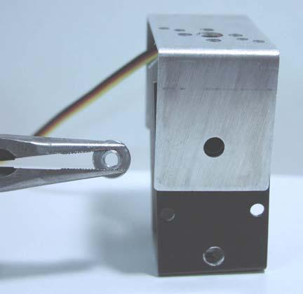Use needle nose pliers to position binding post behind the servomotor so that the hole of the binding post is aligned with the holes