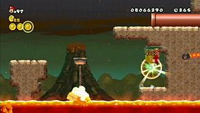 Wait until the lava spout is down, then run and jump across the gap, adding in a Wii Remote shake for a horizontal boost.