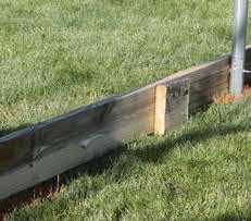A baseboard runs the length of the frame and provides a seal between the finished grade and the termination spring channel.