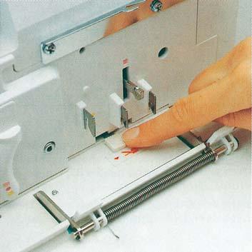 Lower the swiveling stitch width latch (see page 31) and disengage the upper blade (see page 30).