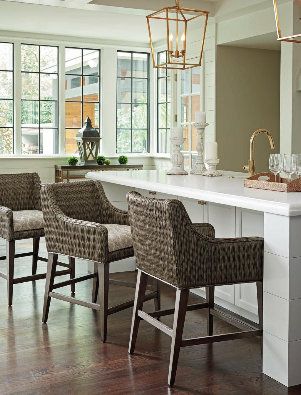 The Turner counter and bar stools feature a woven rattan frame in the Smoke Gray finish with an upholstered seat.