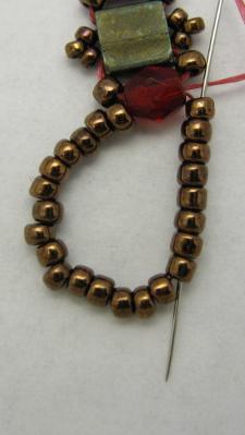Pick up about 23 copper 11/0 beads; pass through the 4MM bead to create a loop. 64.