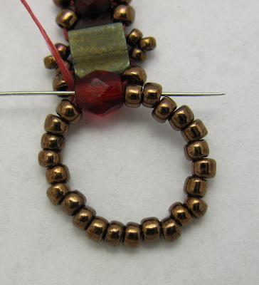 66. Pick up 3 copper 15/0 beads and bring your needle through the 2nd and 3rd bead in the ring.