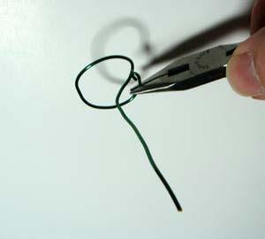 Use pliers to bend a one-inch diameter circular "base" and then bend the wire to the center of the circle.