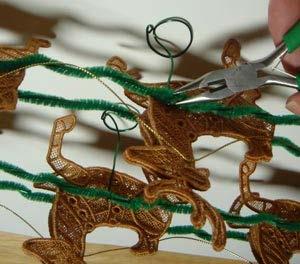 sleigh). Insert the end of the wire in between the reindeer and harness and then bend the wire around the harness.