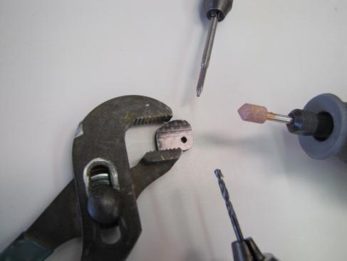 Use a suitable Channel Lock tool to hold the CF reinforcement tab to 1 st drill out the hole with a #43 bit.