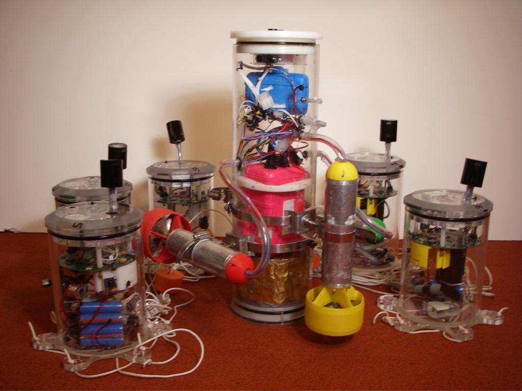 Figure 5-4: A picture of AMOUR and some sensor nodes. The robot has all of the capabilities of the sensor boxes as well as a more advanced camera system for use in local obstacle avoidance.