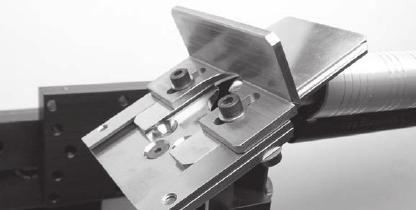 A slit blade ready to millgrain or set channels is shown in use with the milling table positioned at a horizontal angle.