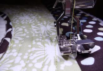 Stitch-in-the-ditch along the outside borders using Edgestitch Foot #10 (10D for the BERNINA 830 with BERNINA Dual Feed) or Walking Foot #50 with the new Center Guide Sole.