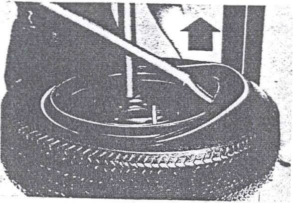 Position wheel (narrow side of bead seat up) in the two manually located clamps and secure the wheel to the table with screw operated clamp.