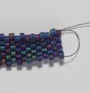2) Fold your work lengthwise, and do a circle stitch through the bead on the opposite side of your tube.