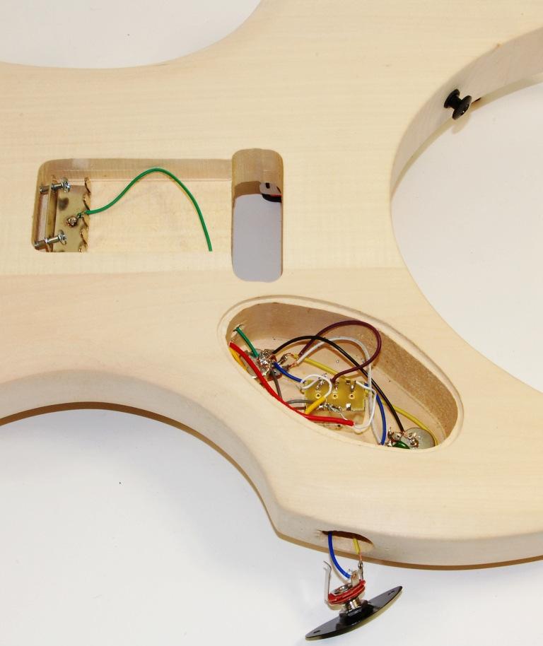 On the first photo on the left side you can see the position of each switch and other electric parts inside of the electric panel at the back of the guitars body.