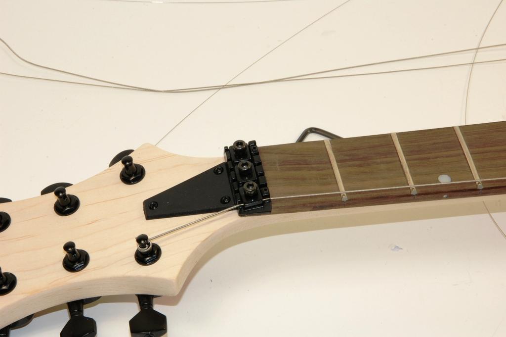 In fact of this the tuners for the three thicker strings have to be rotated into direction of the headstocks end away from your body.