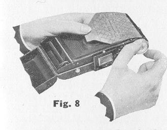 In a subdued light, open the back of the Kodak. Hold the end of the paper taut and turn the knob until all of the paper is on the roll (Fig.
