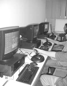 Figure 4. Three participants (one trainer and two trainees) during a collaborative virtual training using the SideWinder Force Feedback II joysticks.