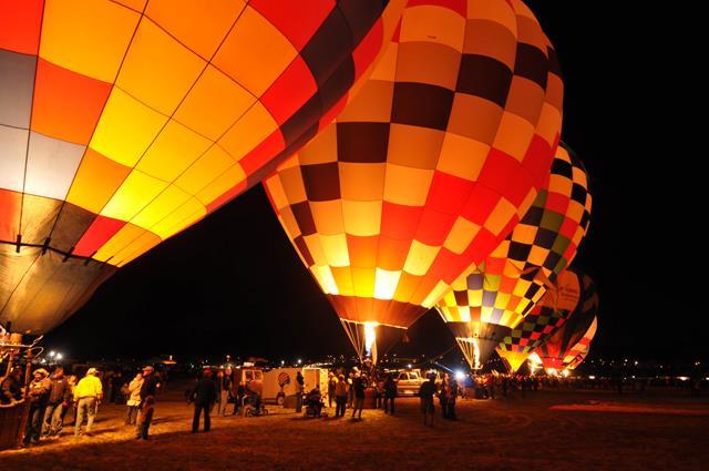 On the launch field, at dusk, you can see the burners of the balloons ignite and watch the evening sky fill with a bouquet of bright colors, as they lift off.