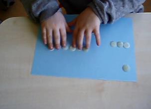 Pupils model the operation with buttons.