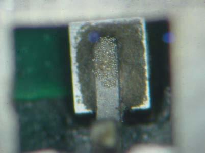 Evidence of oxidized solder balls on top of the tab. Improper wetting to the tab is shown.