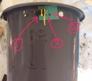 Put the cable ties through the green thing, then into the bucket then back out through the lower holes in the bucket and rectangle.