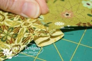 ) Fold the adjacent strips at the seam and bring together at the center crease of the inner strip.