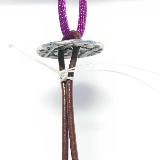 Using the scrap cord, loop it through the center of the leather next to the knot you just tied, and then around your tray (or macrame board, or cookie sheet, or Bead On It Board) and then loop it