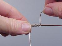 Step 2 Rotate the upper wire away from your body. Continue rotating the 18-gauge wire onto the 14-gauge to form a coil.