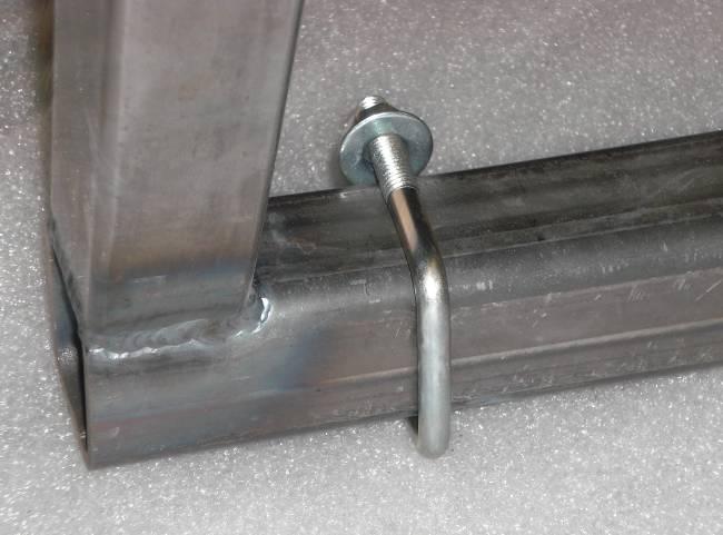 13. While holding the tire rack so the contact is against the magnet, use a small drill bit to drill a pilot hole through the two holes already in the support bracket and through the sheet metal on