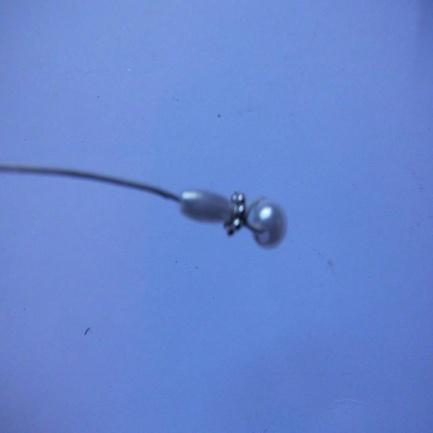 Step 7. Twist the end of the wire around the bead and leave the end so it falls up the length of the single wire.
