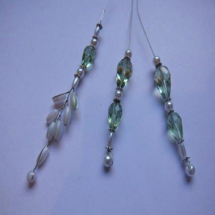 Continue to work the piece by adding a small spring green faceted bead next and then a spacer, small pearl, spacer, a