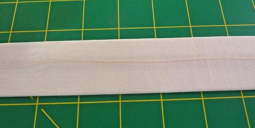 Find the lining strip. Place it wrong side up and flat on your work surface. Find the interfacing strip.