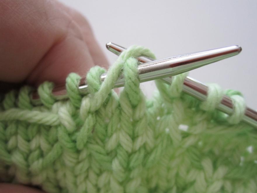 of executing the stitch is to lift the strand up and over the knit stitch so it s