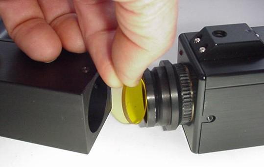 figures below show a blocking filter being placed in the C-mount and the C-mount/camera assembly being installed on the video microscope.