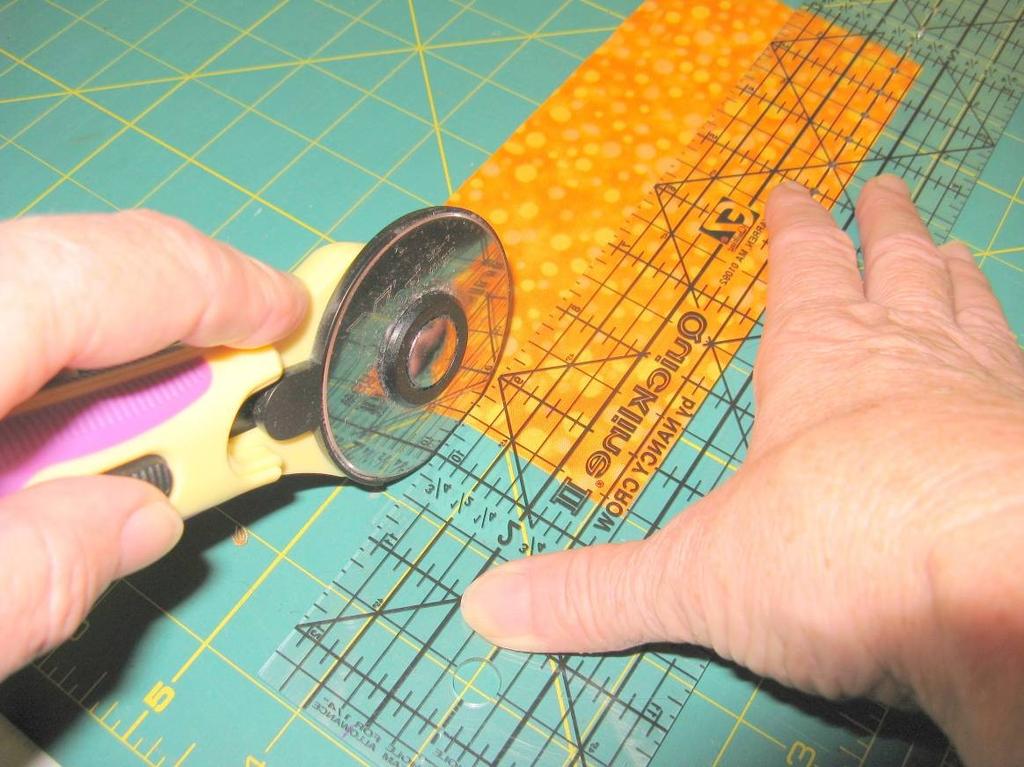 How to Use a Rotary Cutter Lay your fabric on the mat, line up the edge of the fabric to the lines on the mat. Place the ruler along the fabric where you will make your cut.