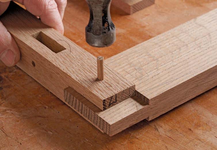 After drilling through the slots and mortises in the legs, dry-fit the joint and use a drill bit to mark the center of the hole on the tenons.