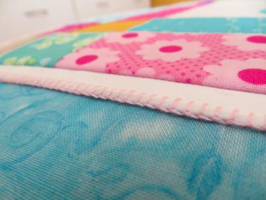 12. Measure the width of the quilt through the centre and trim a strip to this length from each of the pink spot and light cream fabric strips.
