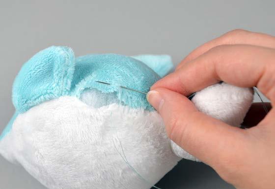 Thread a hand-sewing needle and knot it at the end. Insert the needle from the inside of the opening and out of the plush near one edge of the opening.