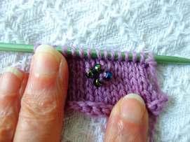 Now go ahead and make your own design using these 15 stitches. In photo to the left you see that I secured 3 beads in a row. Here is a view of the back side of the knitted fabric.