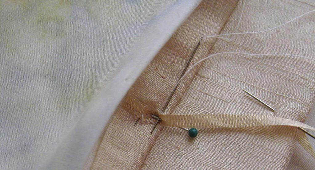 Find the center of each end of your needle case and pin the ribbon in place (in between the wrong sides of the stitched outer piece and the lining).