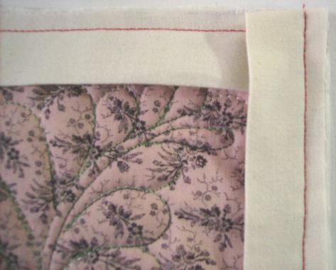 1. When you receive a quilt, you will see that the person who attached the binding, sewed corners as shown here, with the binding layered and turned to prepare for a