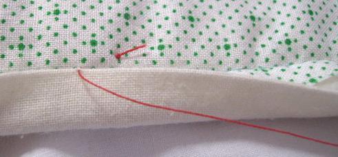 8. Pull the needle and thread through so that the knot is on the surface of the quilt back.