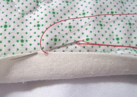 Insert the needle into the backing right next to where it emerged from the binding.