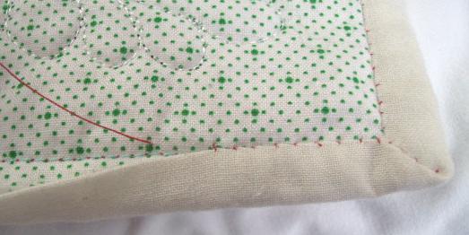 Insert the needle into the quilt between the backing and